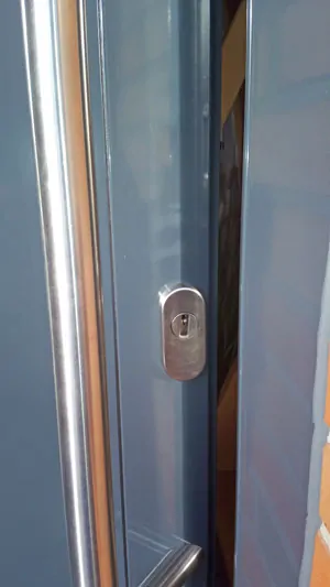 Hier als Beispiel eine Rahmen-Schutzrosette, da der Rahmen an der Tür nicht breit genug für eine runde Schutzrosette ist. Wichtig ist der gekröpfte Stossgriff, da die Hand sonst am Türrahmen "schrappen" und der Schlüssel nicht ins Schlüsselloch passen würde.
